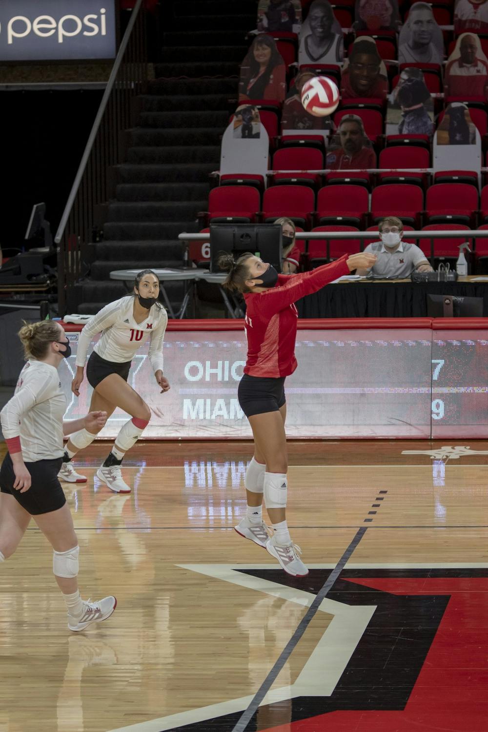 <p>Senior libero Abigail Huser (pictured, in red) executes a bump during a week series vs. Ohio University.</p>