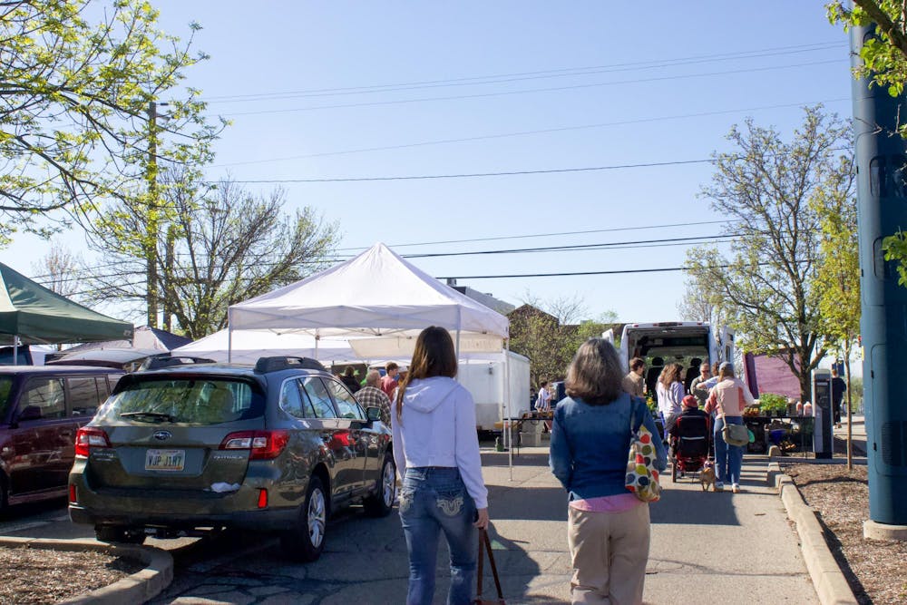 People walk into the Oxford Farmer’s market Saturday morning.