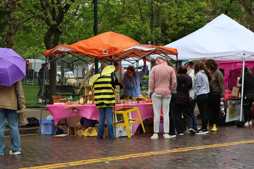 People stand by the honeybee booth during the Bee Festival.