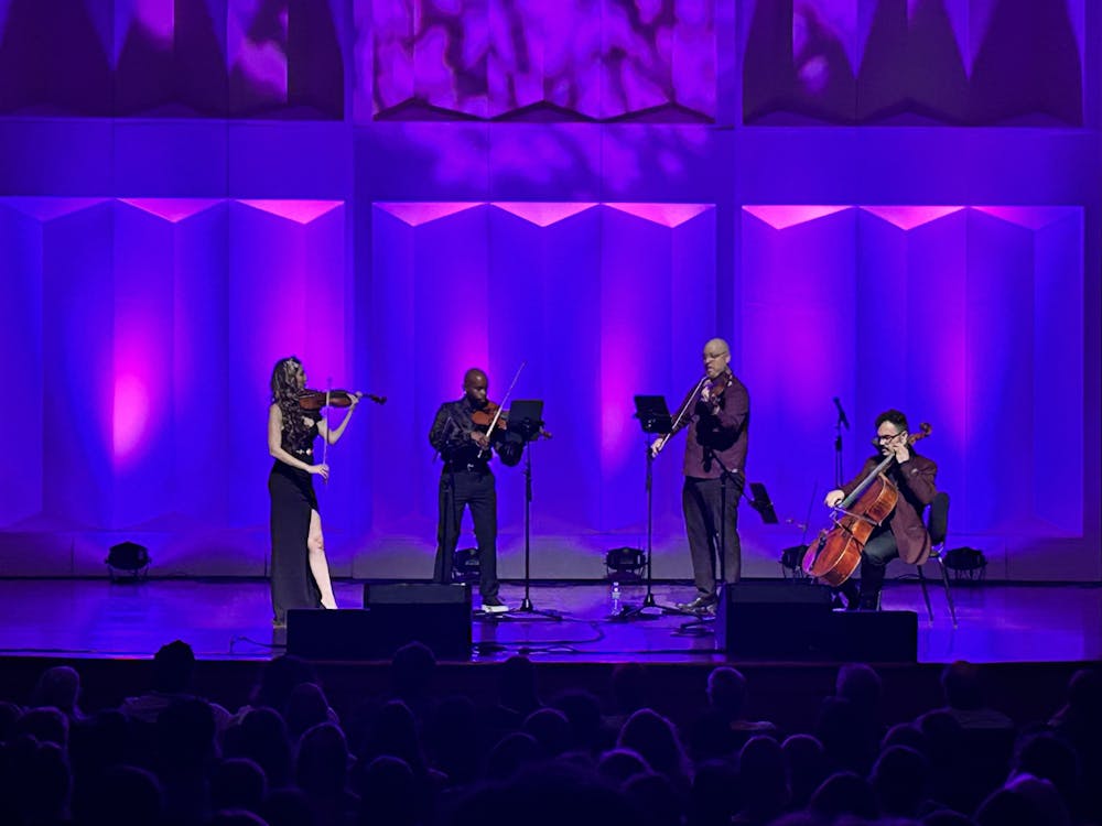 The Vitamin String Quartet, performing at Hall Auditorium on Tuesday, Oct. 24, played Prince's “Purple Rain” in front of a royal purple background.