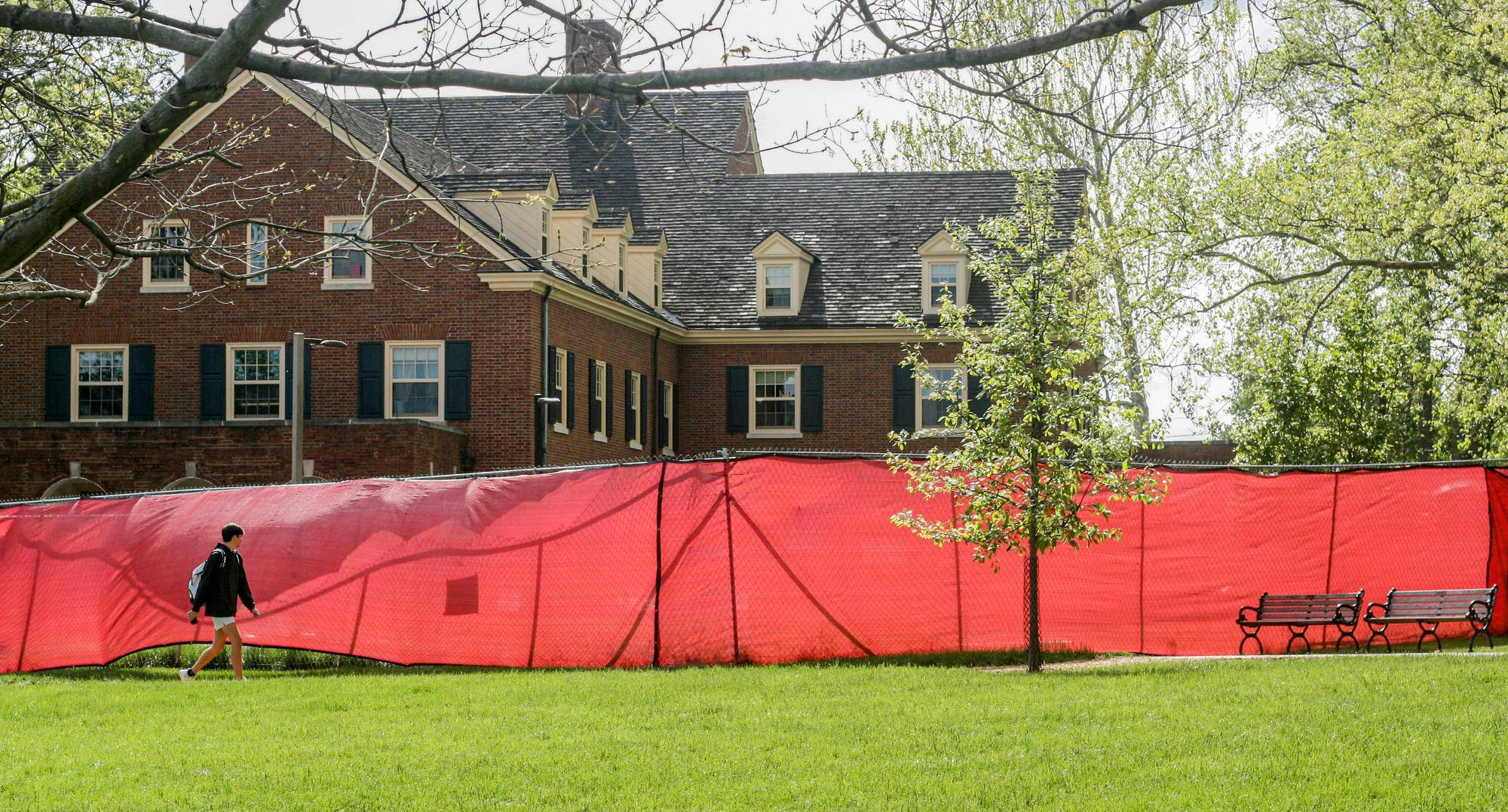Student walks on Central Quad past construction site outside Hamilton Hall.