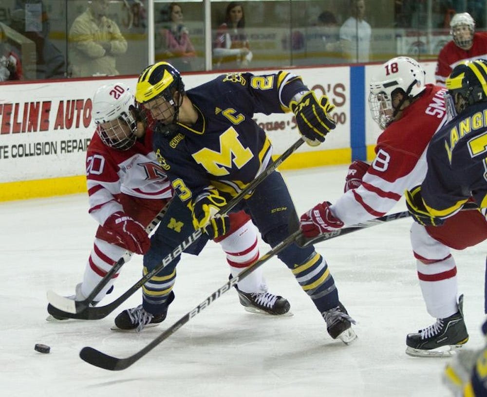 Pat Cannone fights for the puck during a face off against Michigan's Luke Glendening in the second period.