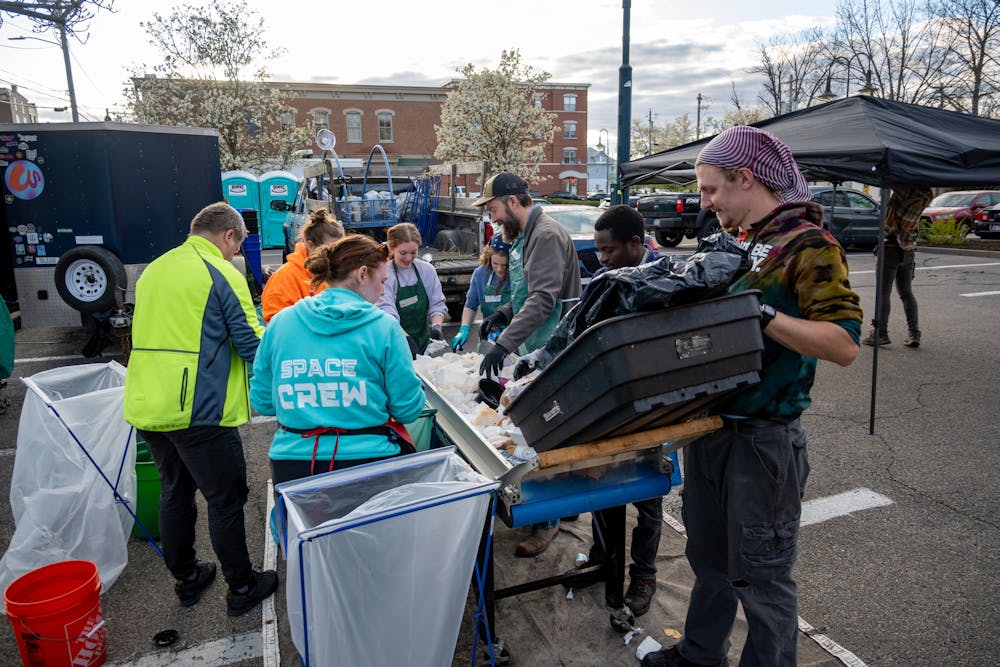 <p>Volunteers stand around a conveyor belt at the April Solar Eclipse event and sort waste by hand into the correct bins. Photo provided by Reena Murphy</p>