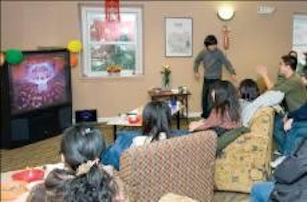 International students watch the traditional Chinese New Year's television broadcast, streamlined live from China's CCTV at Candlewood Apartments Sunday morning.