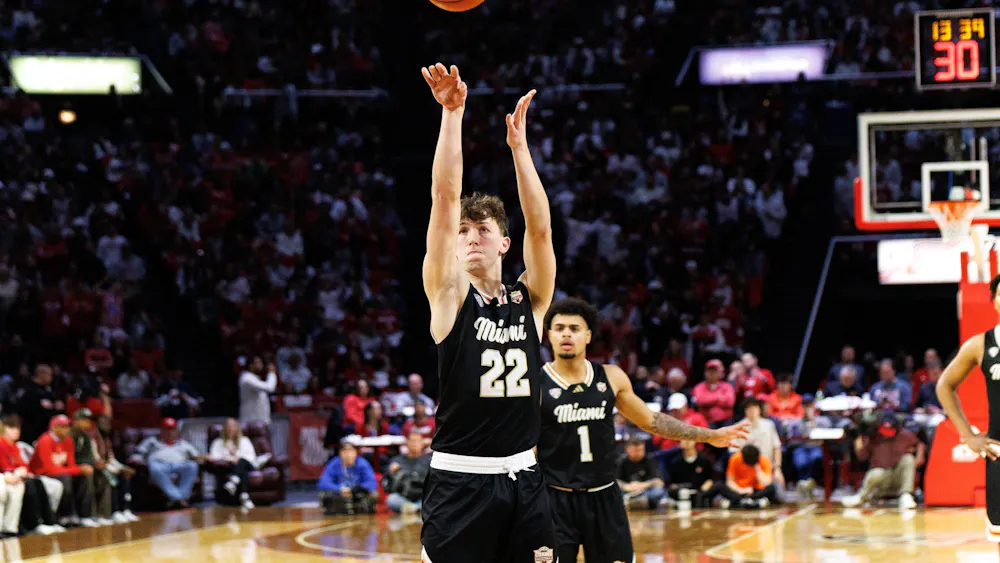 Sophomore guard Brant Byers shoots a 3-pointer in match against the Bowling Green State University Falcons. Freshman guard Trey Perry watches from behind.
