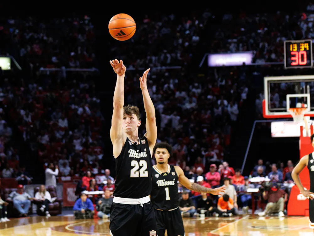 Sophomore guard Brant Byers shoots a 3-pointer in match against the Bowling Green State University Falcons. Freshman guard Trey Perry watches from behind.