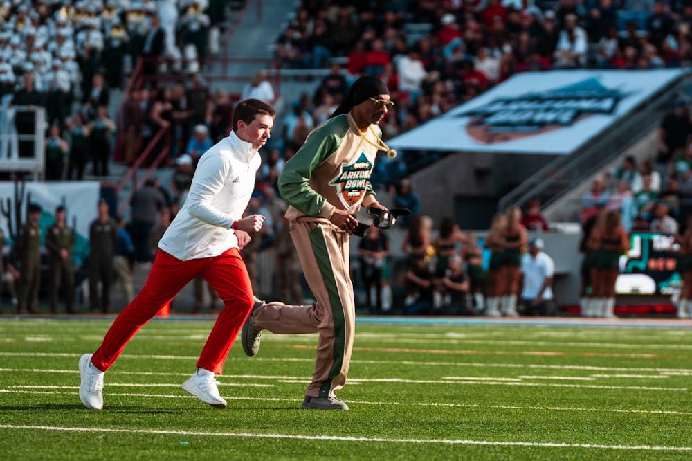 Senior finance major Patrick Reaves running alongside Snoop Dogg at the Arizona Bowl in 2024