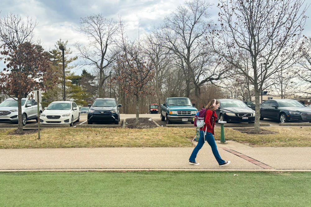 <p>A student walks along the East end of Cook Field, the proposed site for a new arena. The space borders Miami University&#x27;s natural areas and Four Mile Creek. </p>