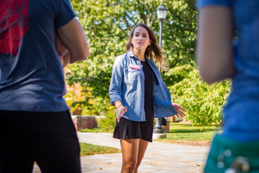 “Kendal Lane introduces herself to the small group standing around her. Her sneakers are Miami red.”