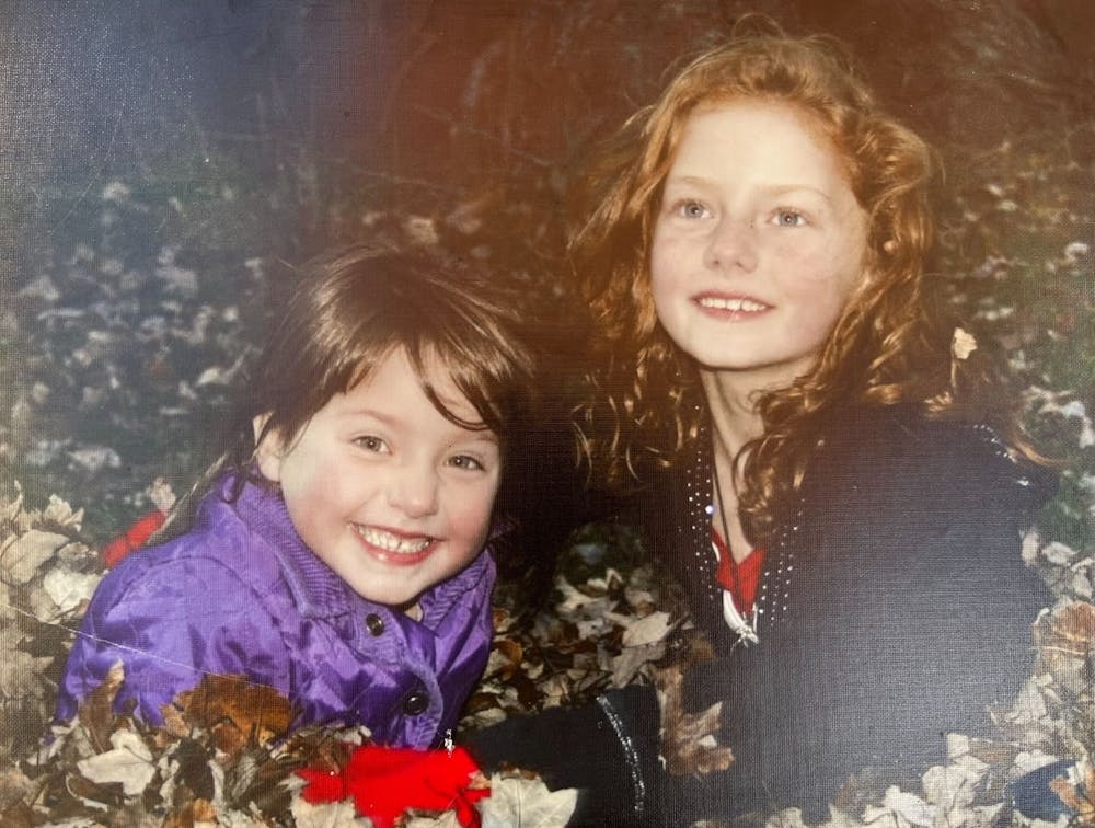 Opinion columnist Ava Kalina, pictured above (right) with her sister (left) in childhood, enjoyed catching fireflies in her backyard as a child -- but is worried about the rapidly falling rates of her beloved bugs.