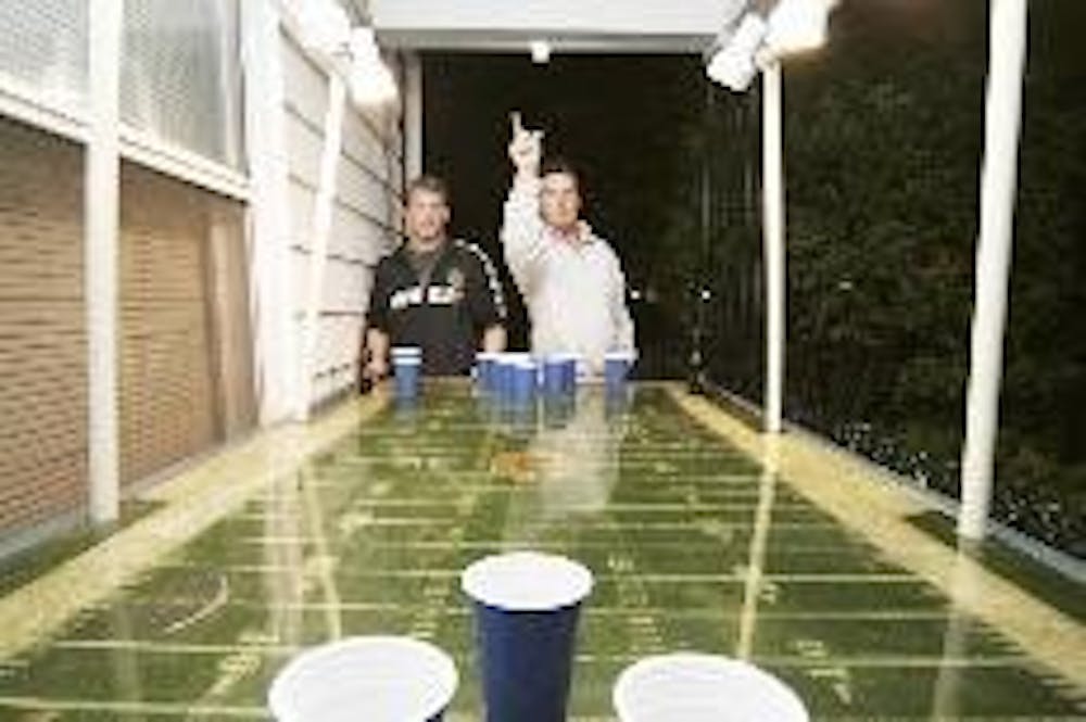 Juniors Ryan Soskin and Nick Riedel play beer pong outside of a house off of South College Avenue Thursday night.