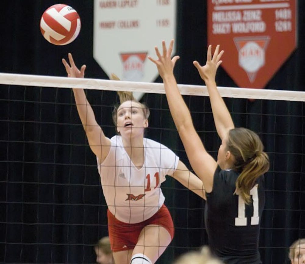 Senior middle hitter Michele Metzler goes up to spike the ball.