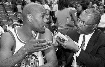 Terence Moore (right) interviews Gary Payton (left) after an NBA game.