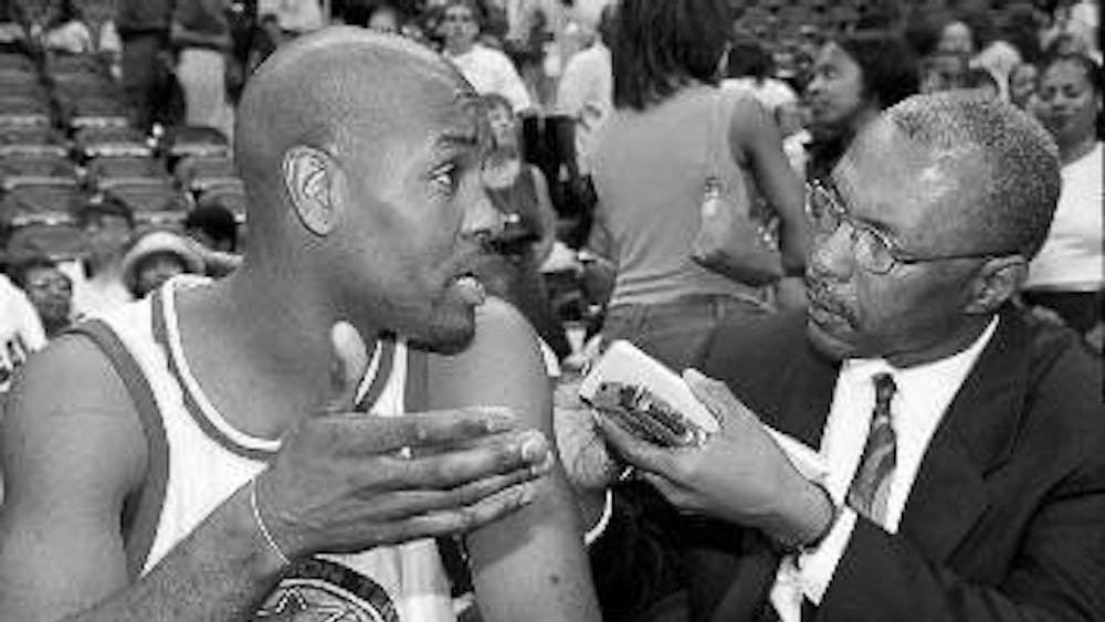 Terence Moore (right) interviews Gary Payton (left) after an NBA game.