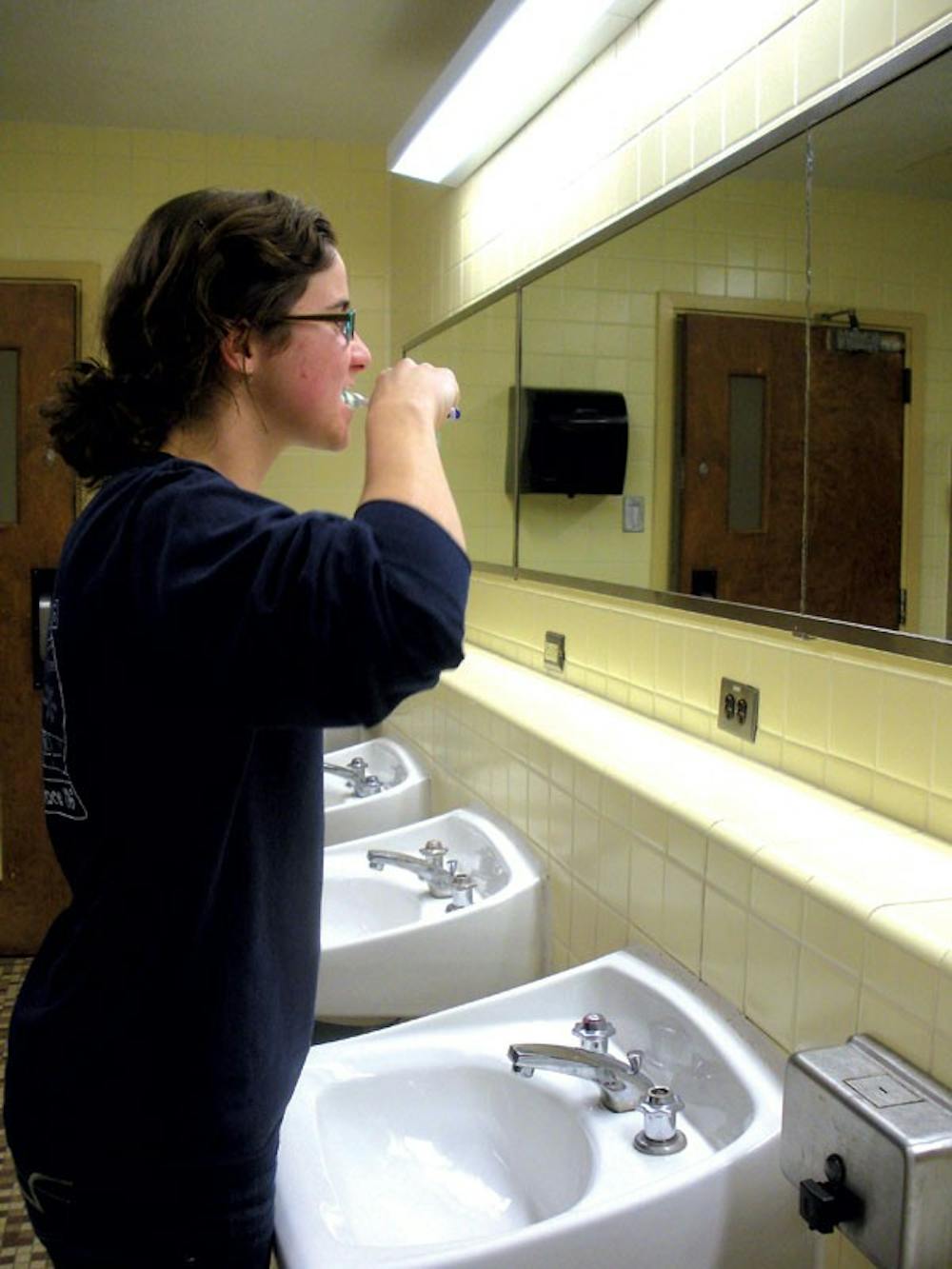 First-year Gabby Trojanowski does her part during Unplugged, Untapped, Game On! by turning off the water while brushing her teeth Wednesday at Emerson Hall.