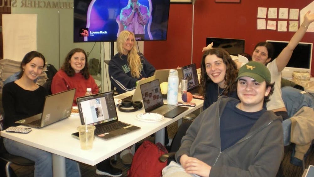 Jayson Brake (far right) works with the design team on a production night.