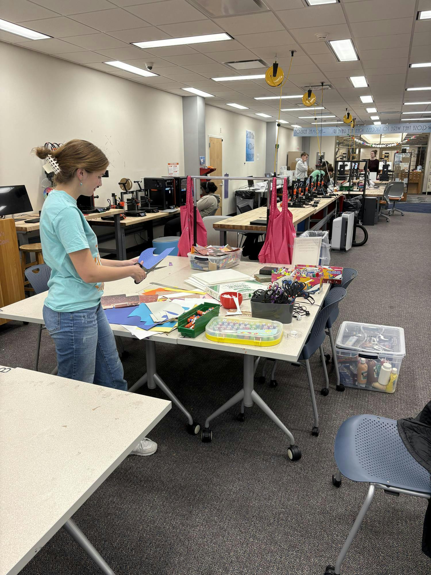 Parker Green cuts a scrap piece of paper in the Makerspace. Photo provided by Parker Green