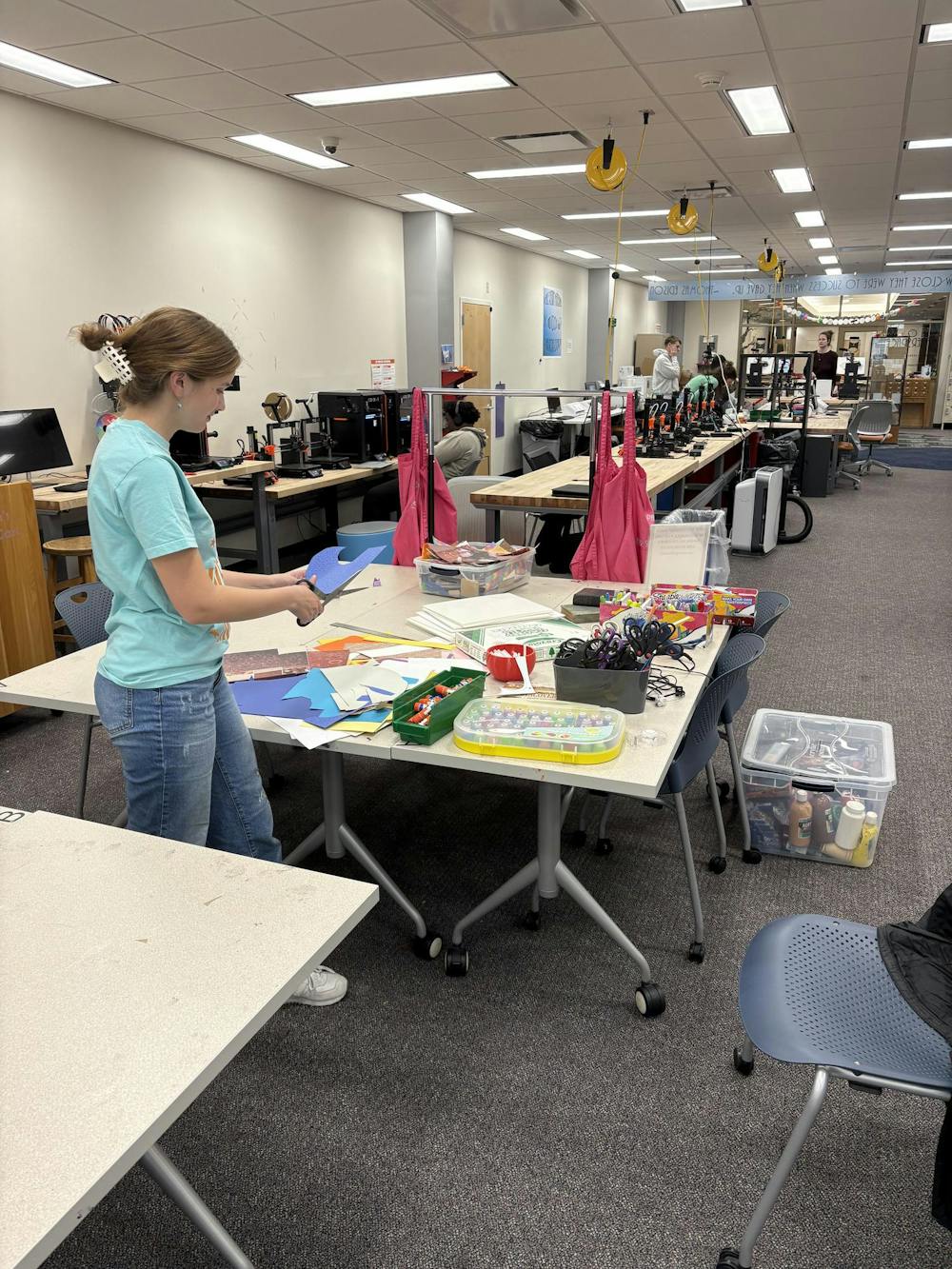 Parker Green cuts a scrap piece of paper in the Makerspace. Photo provided by Parker Green