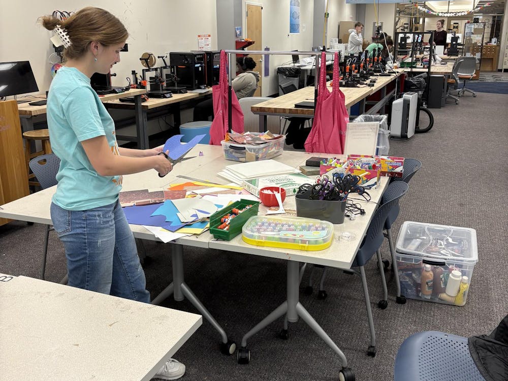 Parker Green cuts a scrap piece of paper in the Makerspace. Photo provided by Parker Green
