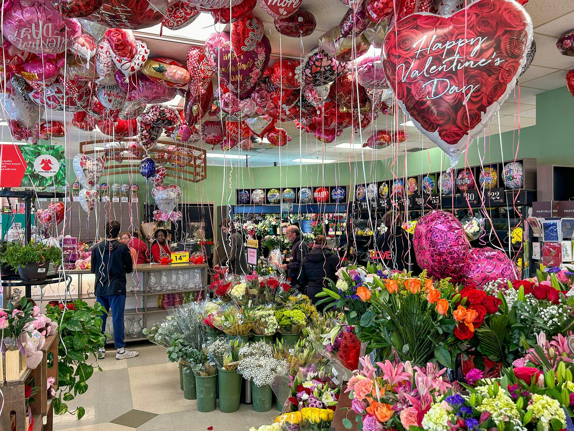 Customers shop for Valentine’s balloons and flowers at the Oxford Kroger store.
