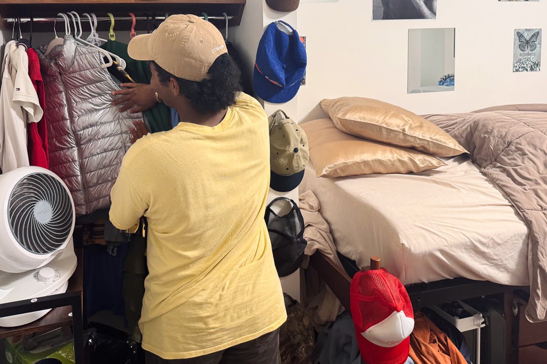 Social Media Manager Kiser Young rummages through his wardrobe.