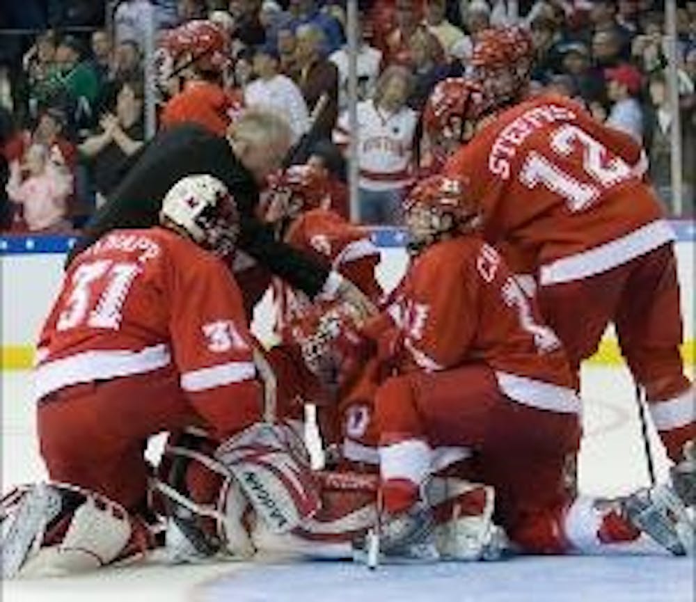 Teammates console freshman goalie Cody Reichard after Boston University scored in overtime to win the National Championship Saturday evening. 