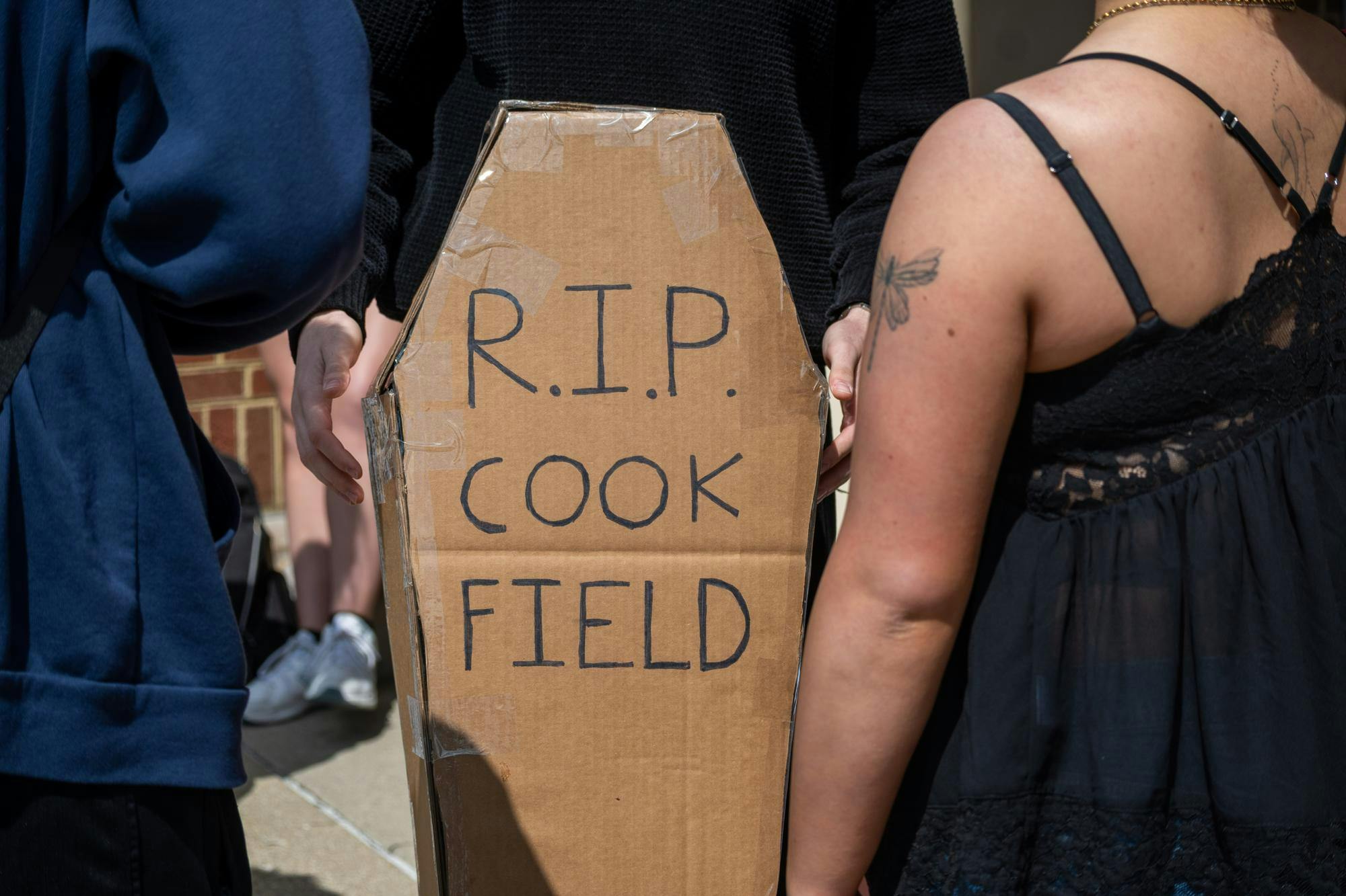 Student stands with cardboard coffin