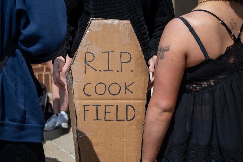 Student stands with cardboard coffin