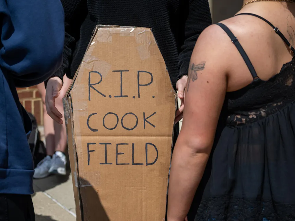Student stands with cardboard coffin