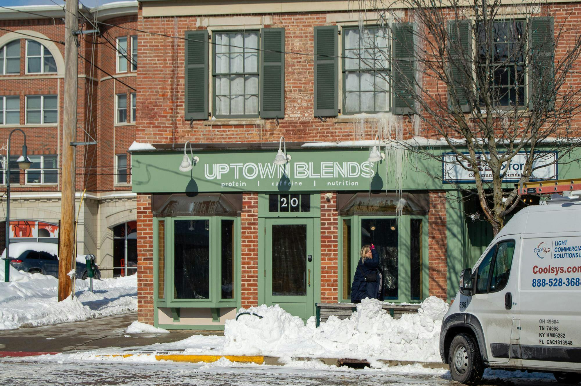Woman walks in front of the now closed Uptown Blends on High Street.