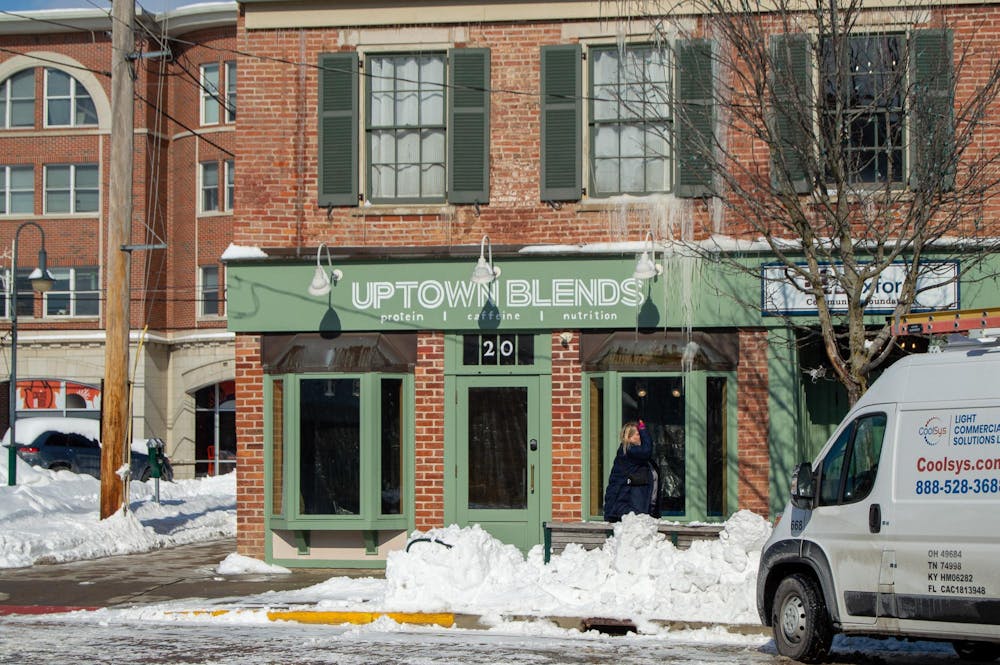 Woman walks in front of the now closed Uptown Blends on High Street.