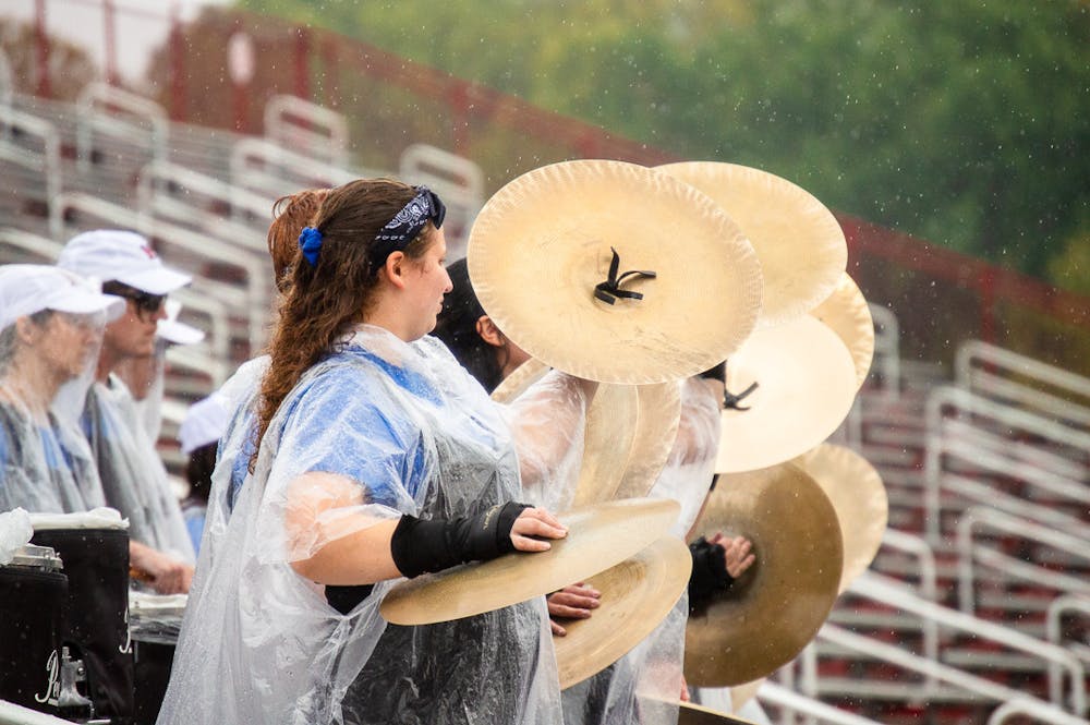 Lindsey Rose Rohrig and other members of the MUMB drumline crash their cymbals during their pep band performance.