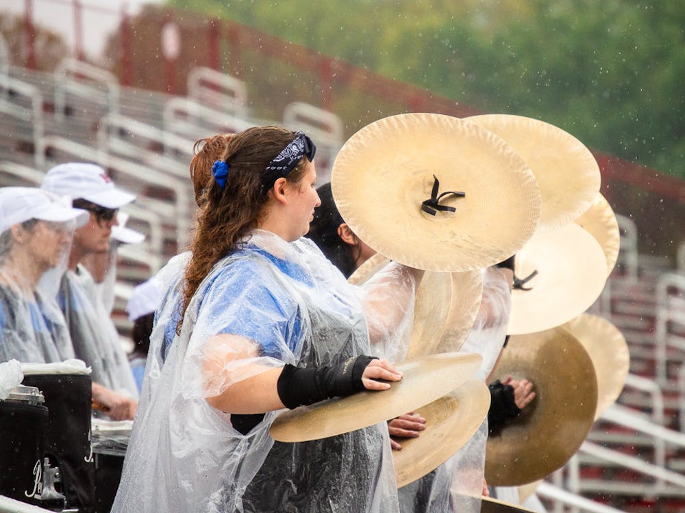 Lindsey Rose Rohrig and other members of the MUMB drumline crash their cymbals during their pep band performance.