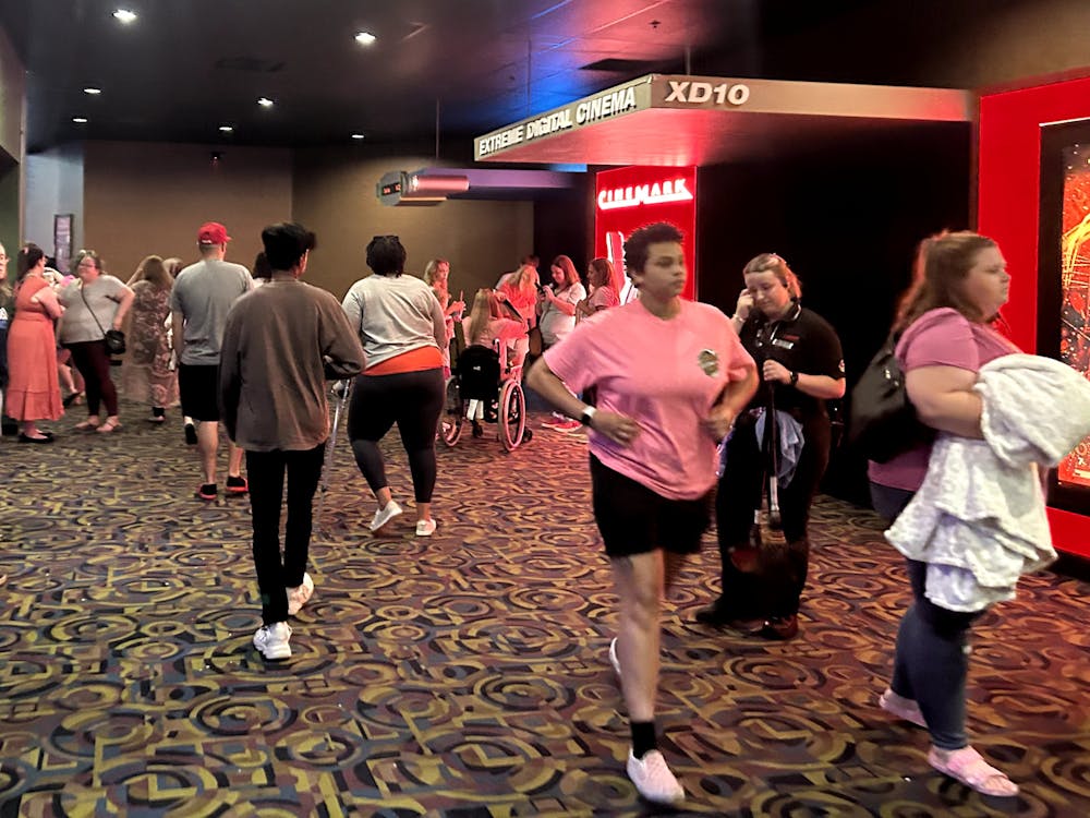 A crowd of moviegoers wait around in their pink outfits after seeing &quot;Barbie&quot;.