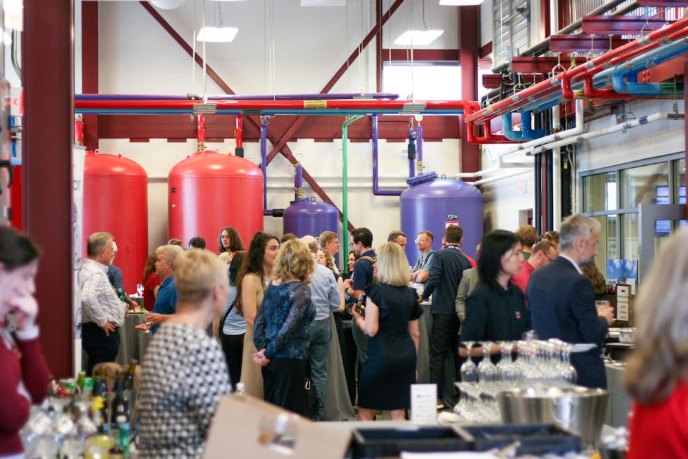 Attendees of the SUSTAIN conference chat during a reception at the Western Geothermal Plant. 