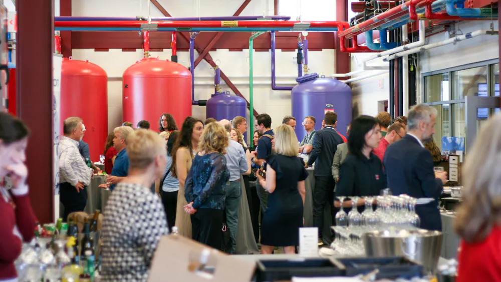 Attendees of the SUSTAIN conference chat during a reception at the Western Geothermal Plant.