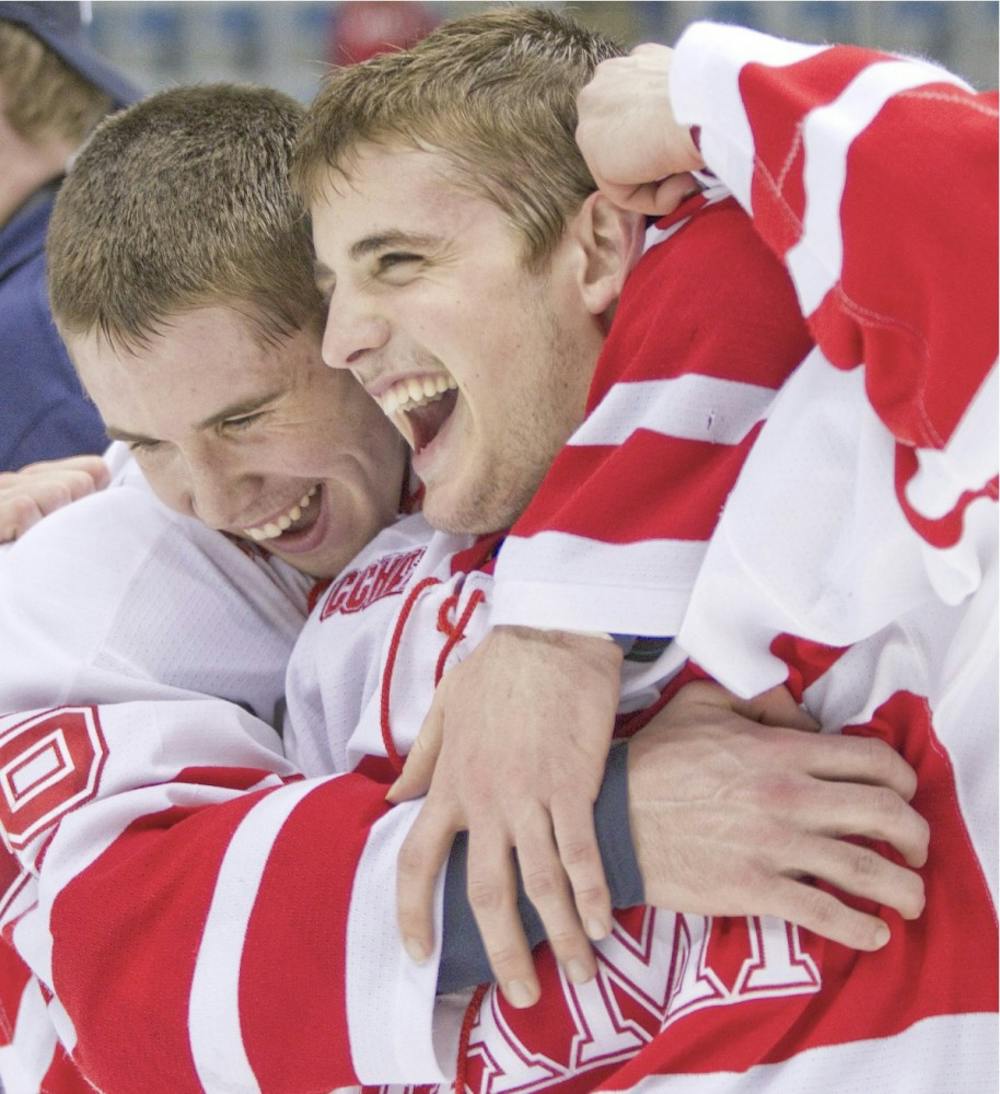 Freshman Curtis McKenzie and sophomore Chris Wideman embrace in celebration after Sunday’s victory over The University of Michigan.