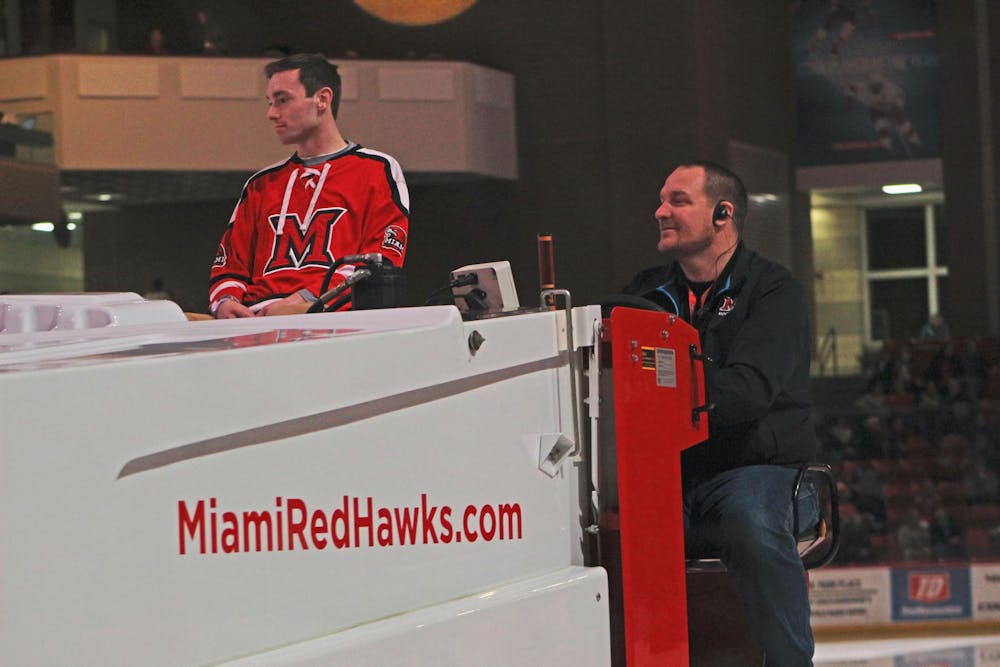 Brandon Hall (right) drives a Zamboni around the Steve &#x27;Coach&#x27; Cady Arena ice during a hockey game between the Miami RedHawks and the Western Michigan Broncos on Feb. 14.