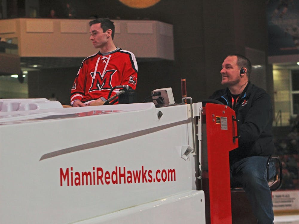 Brandon Hall (right) drives a Zamboni around the Steve 'Coach' Cady Arena ice during a hockey game between the Miami RedHawks and the Western Michigan Broncos on Feb. 14.