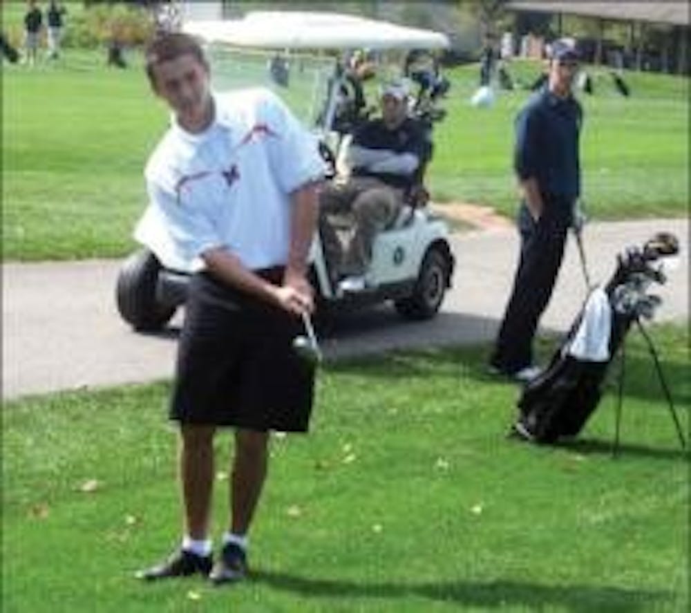 Miami University first-year Will Osterfeld hits a practice chip before teeing off on Saturdaywith the club golf team. 