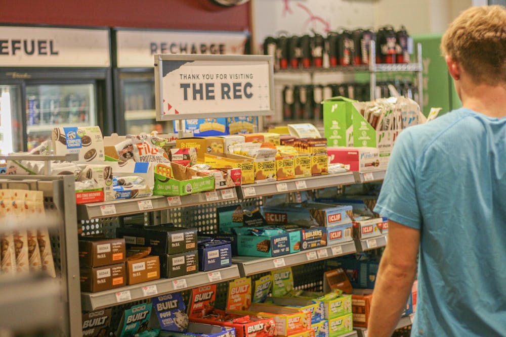 <p>Student looks at protein snacks in the Rec center store.</p>