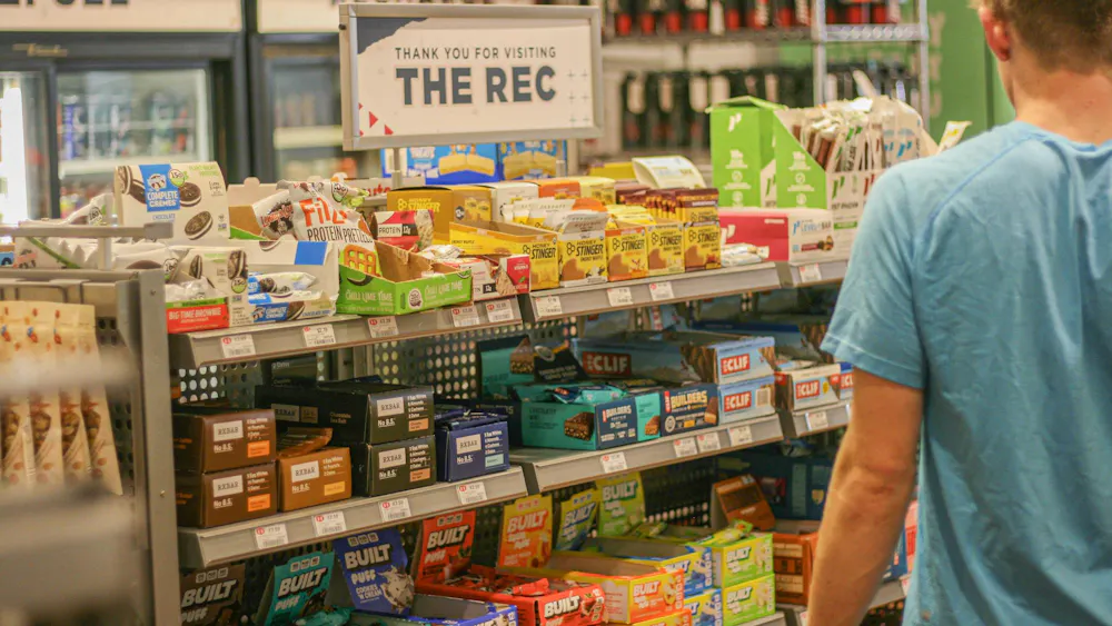 Student looks at protein snacks in the Rec center store.