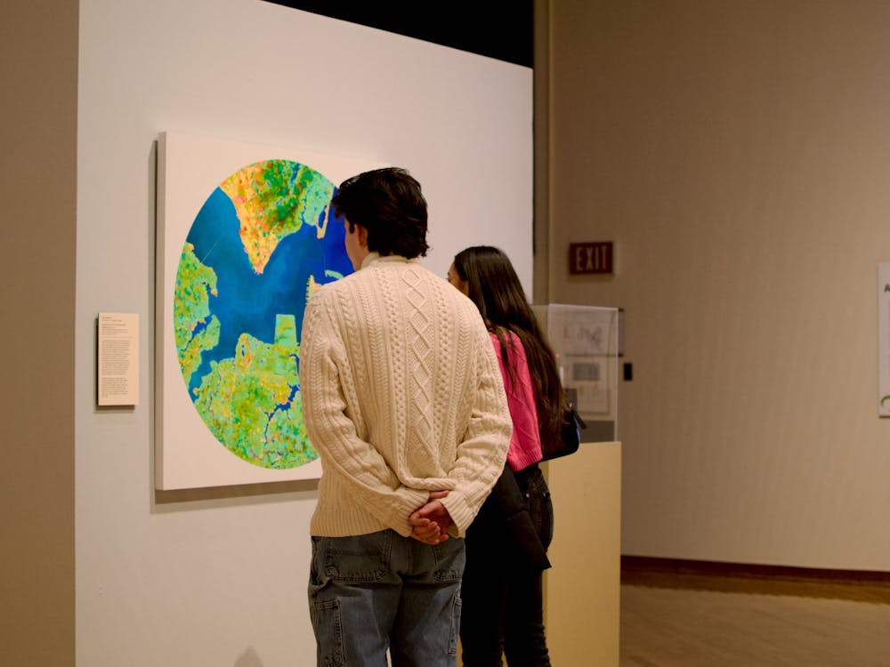 Two museum-goers examine John Sabraw's Aerial Chroma S1 2, which was painted using pigments extracted from residue left over from abandoned mines.