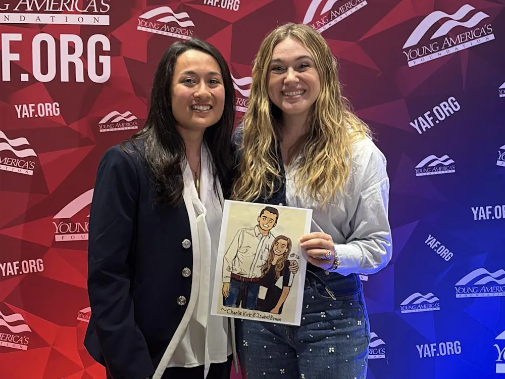 Josie Zimmerman (left) and Isabel Brown (right) with a drawing Zimmerman made of Brown and the late Charlie Kirk. Photo provided by Josie Zimmerman