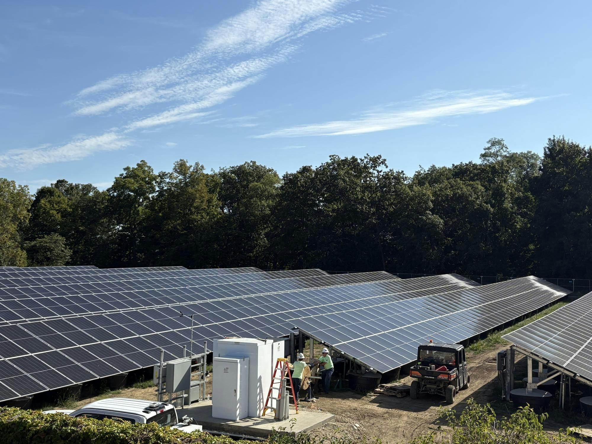 Workers at Miami University's new solar park connect wires to the panels, which will help power the university this October. 