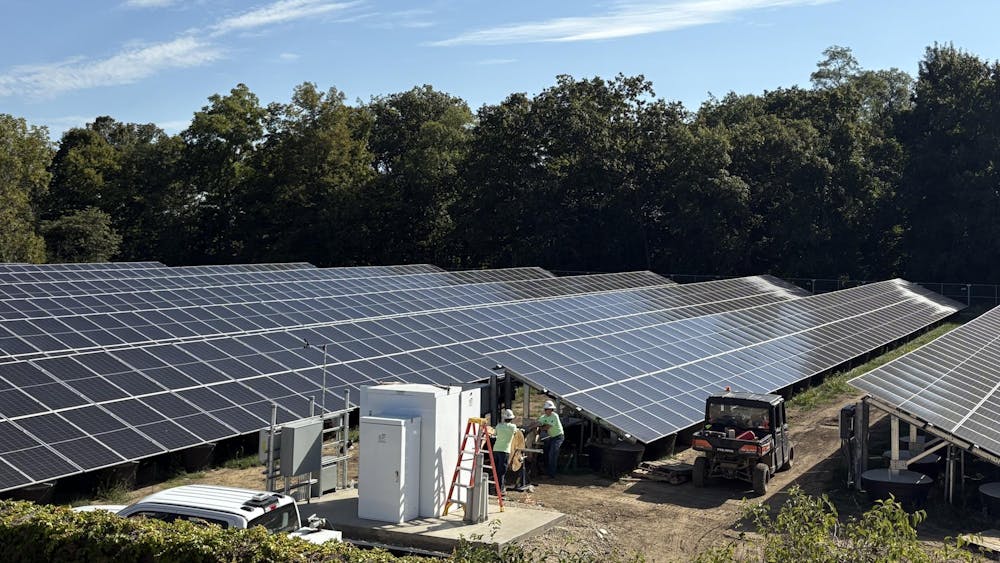 Workers at Miami University's new solar park connect wires to the panels, which will help power the university this October.
