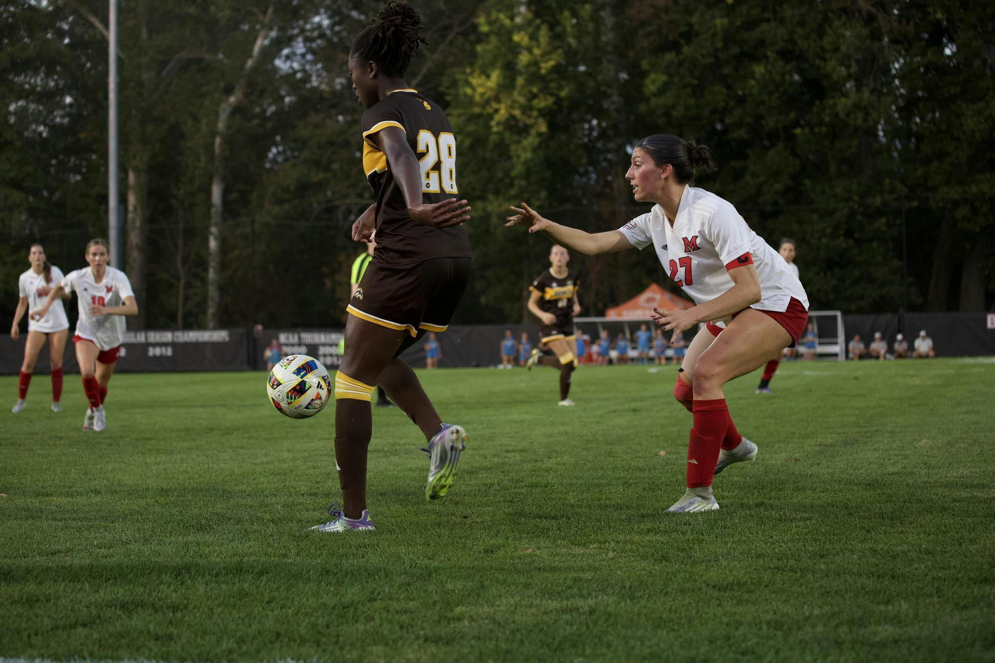 Miami soccer player defends Western Michigan player during game. 