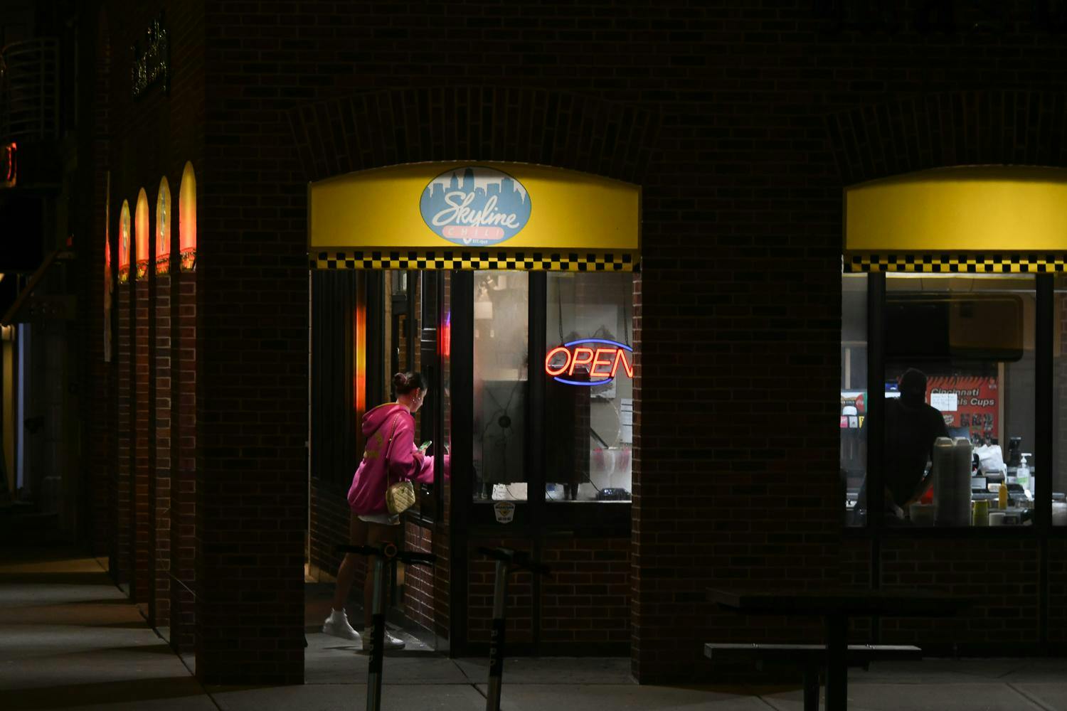 Businesses light up high street late at night. 