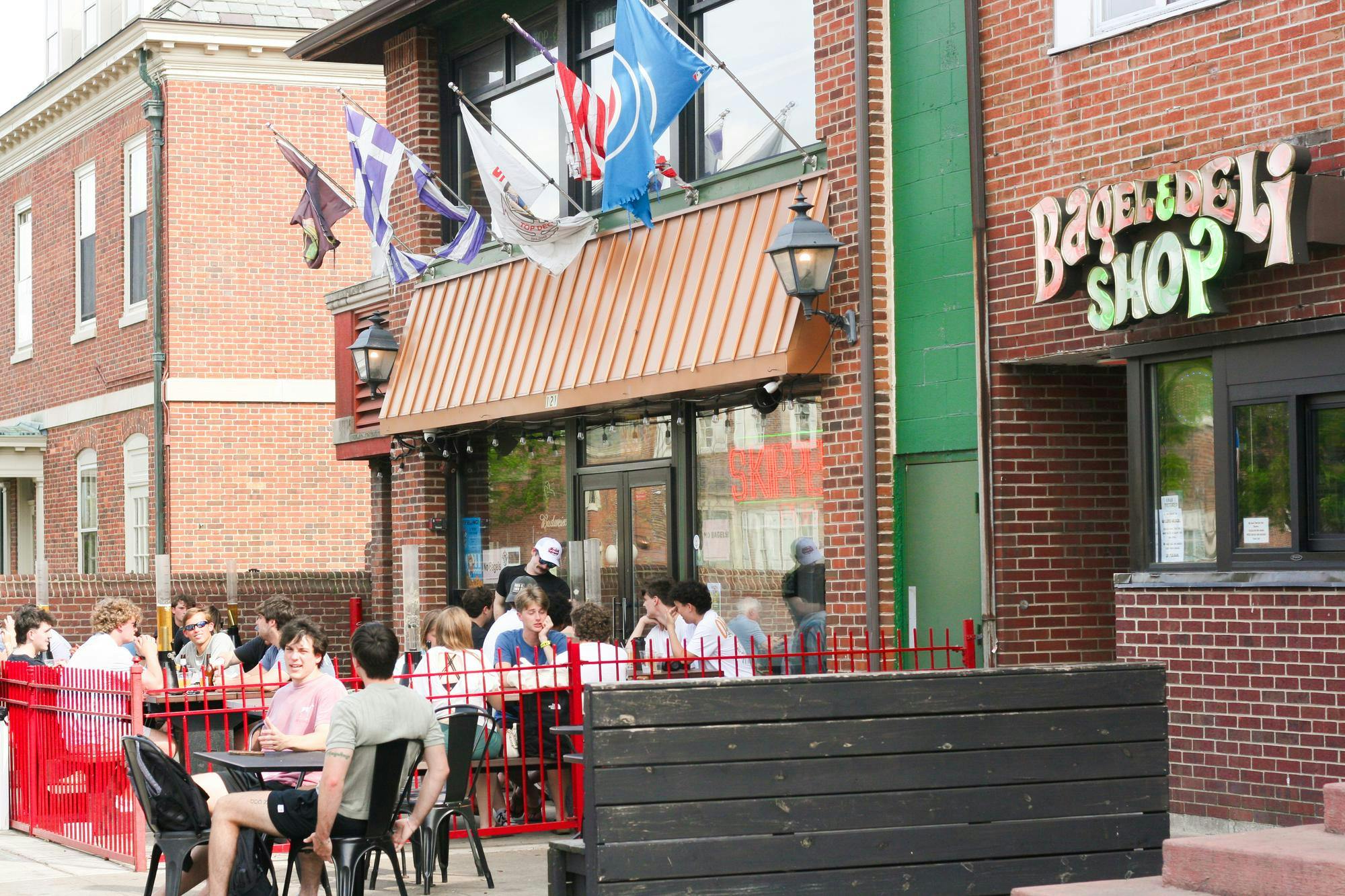 Students gather outside Bagel & Deli Shop and Skipper's Pub on West High Street.