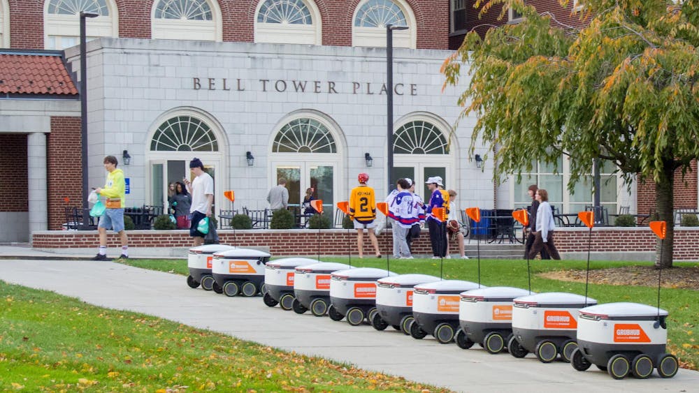 Grubhub robots sit lined up outside Bell Tower Commons.